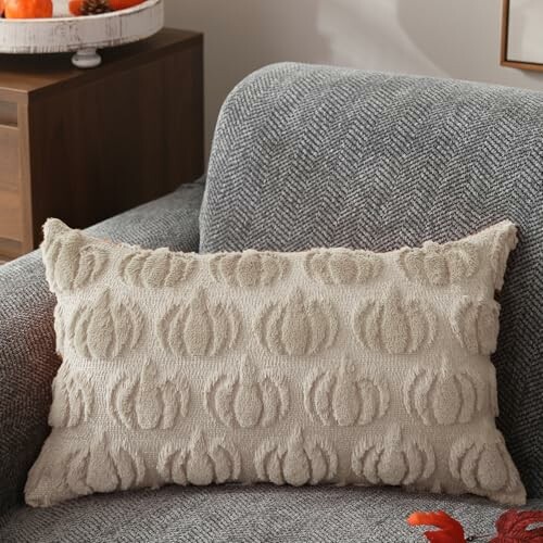 Beige pillow with pumpkin pattern on gray chair